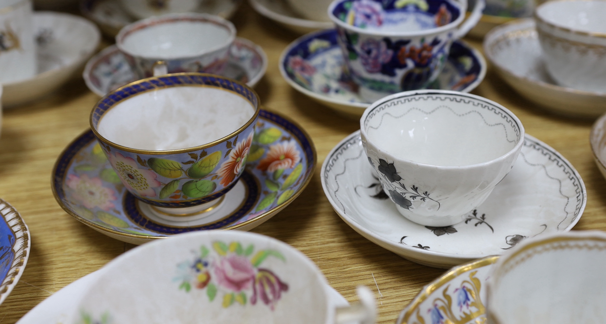 Collection of 18th/19th century English porcelain tea and coffee cups, bowls and saucers, some with hand painted and gilded decoration, the largest 15cm in diameter